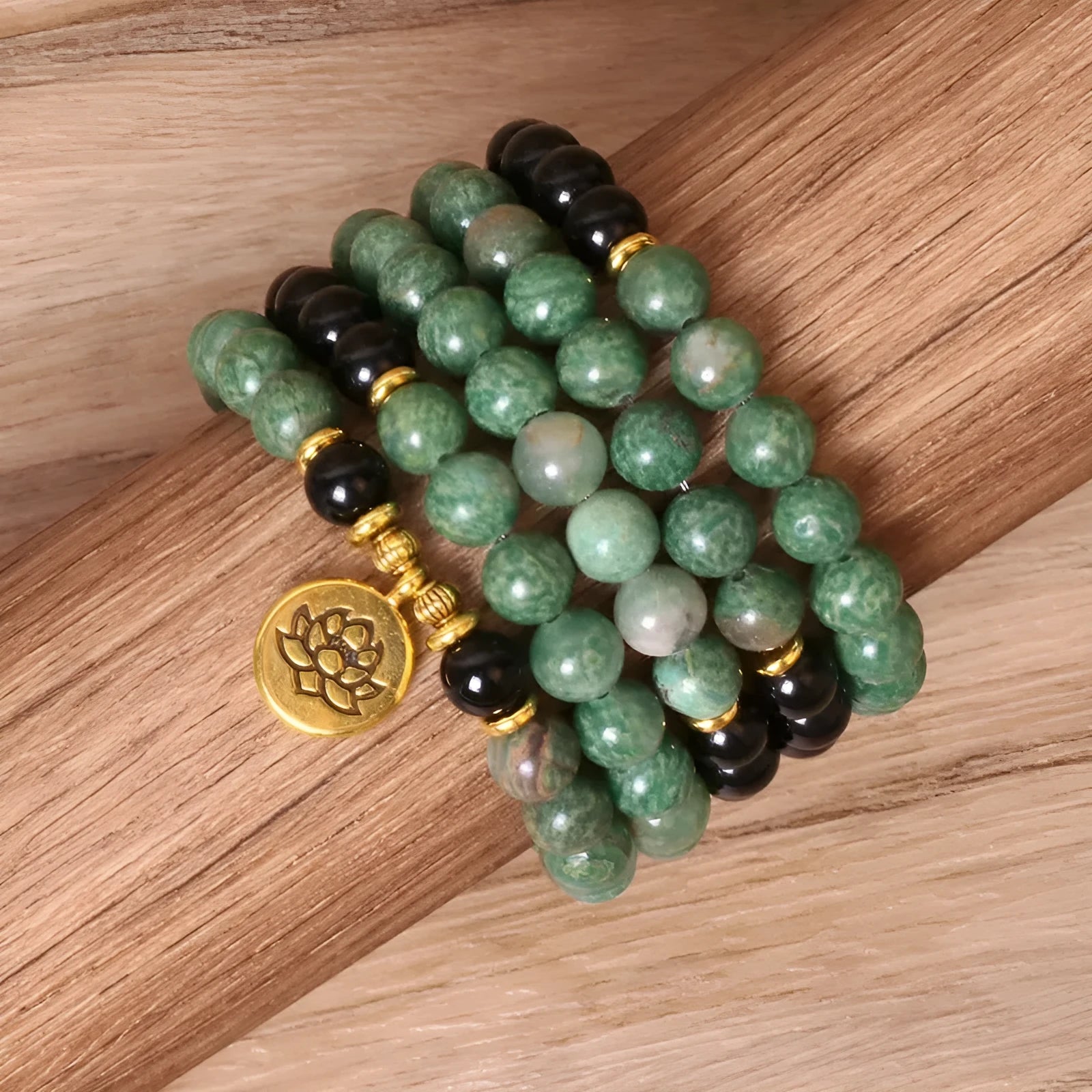 Green and black alloy beads on an elasticated bracelet, shown on a wrist.