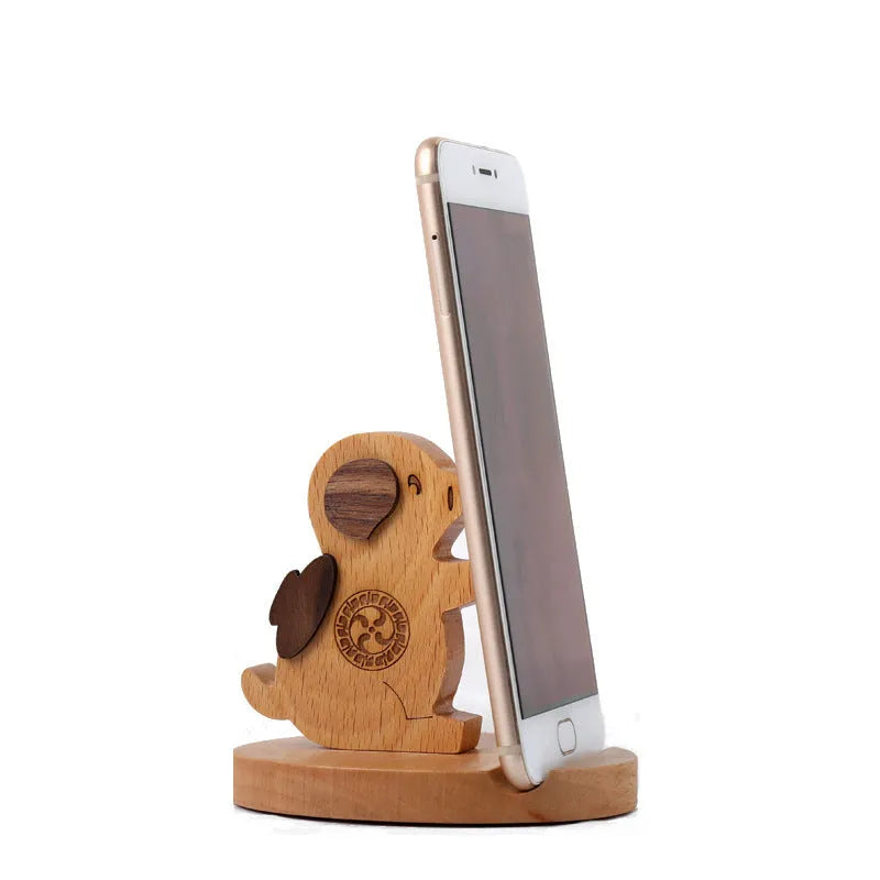 Solid beech wood phone holder with resin puppy decoration and a pound coin in the integrated slot.