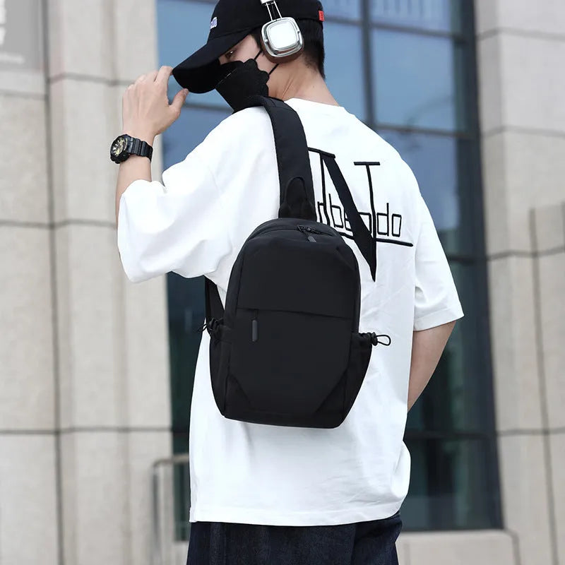Grey men's chest bag worn across the shoulder, showing main compartment and waterproof-treated fabric.