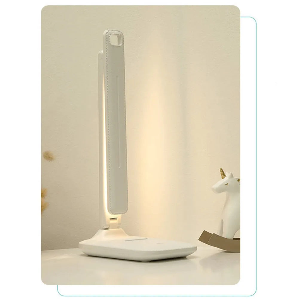 White plastic bedside lamp with touch dimming and colour-changing LED light on a table.