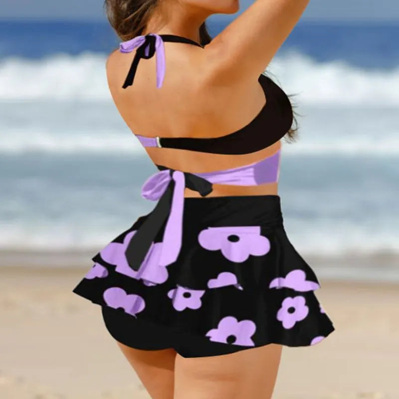 Purple women's bikini set with lace-up front and high-waisted split skirt.