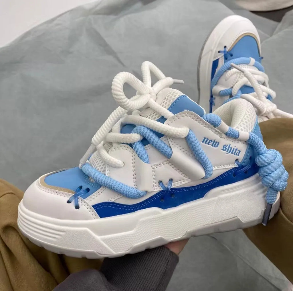 Women's grey retro chunky sneakers with thick sole and front lace-up, shown on a foot