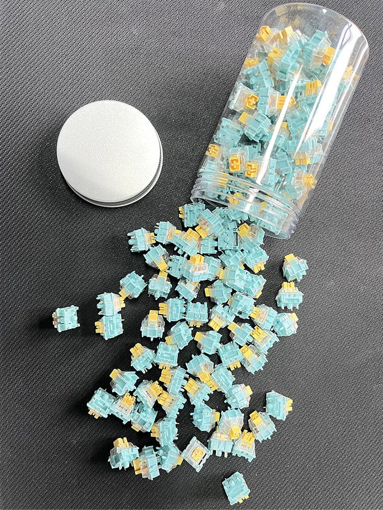 36 Sea Salt Lemon coloured mechanical keyboard switches with 3-pin connectors laid out on a table.