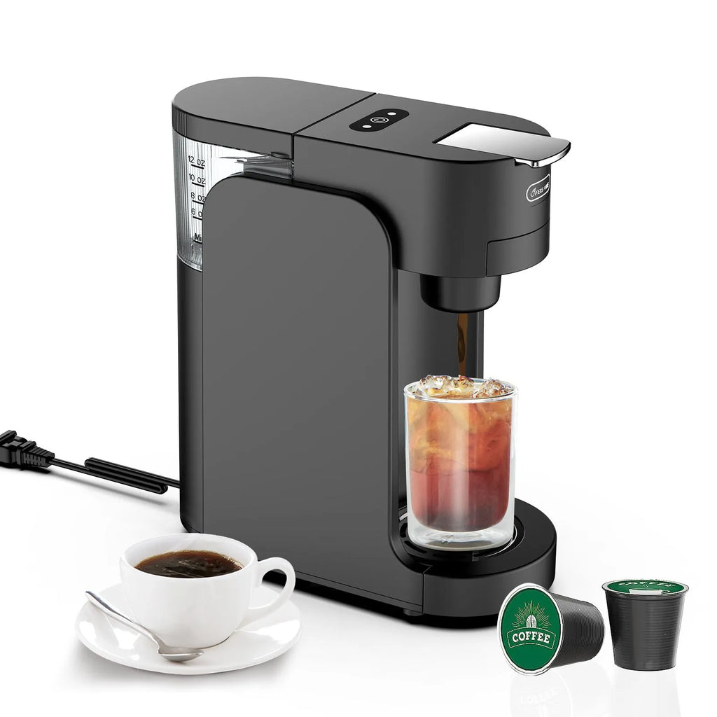 Black and white mini capsule coffee machine with transparent water tank and stainless steel drip tray on a kitchen counter