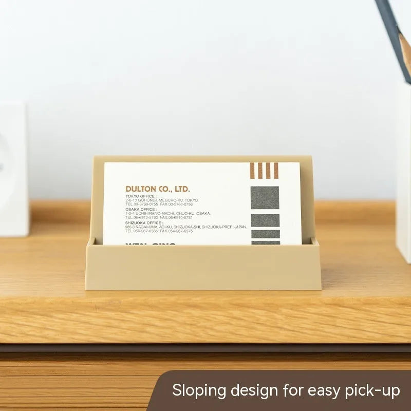Creative PS geometric business card stand in brown, holding 20 cards upright on a desk.