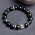 Obsidian unisex bracelet with silver detail in 10mm and 12mm bead size options on a wrist.