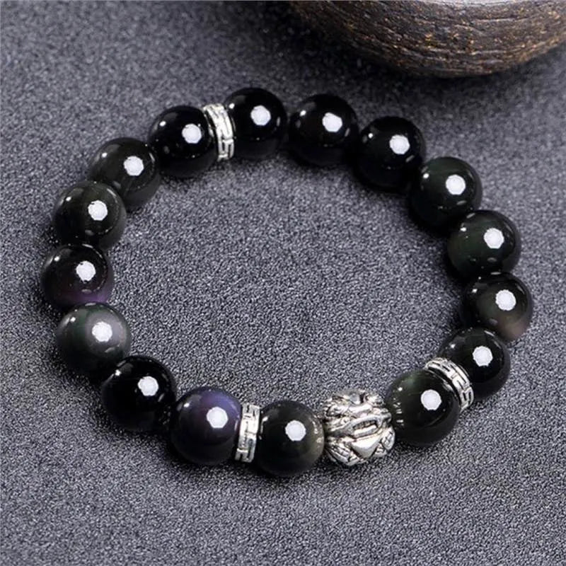 Obsidian unisex bracelet with silver detail in 10mm and 12mm bead size options on a wrist.