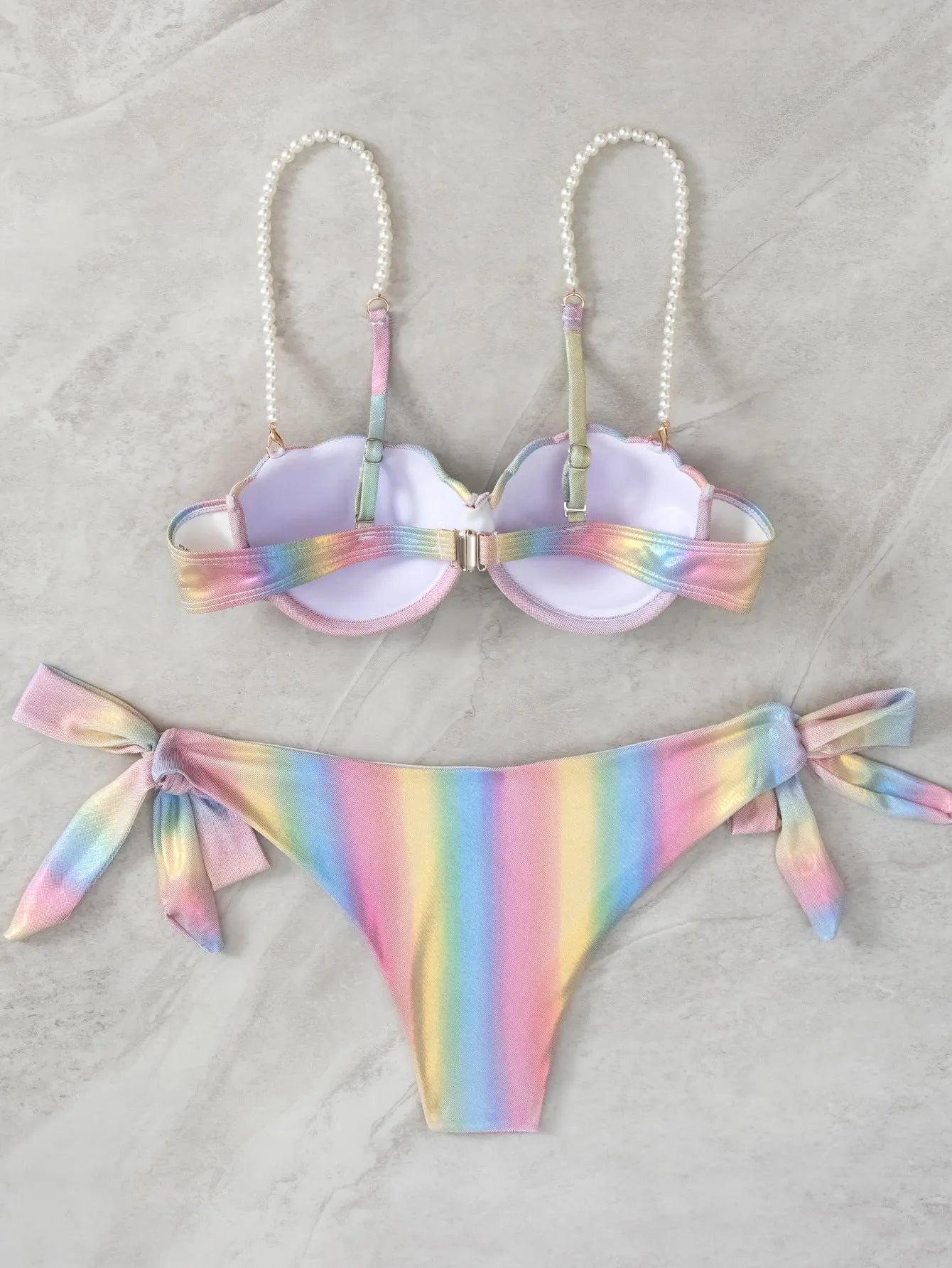 Women's rainbow colour adjustable tied bikini swimsuit on a hanger.