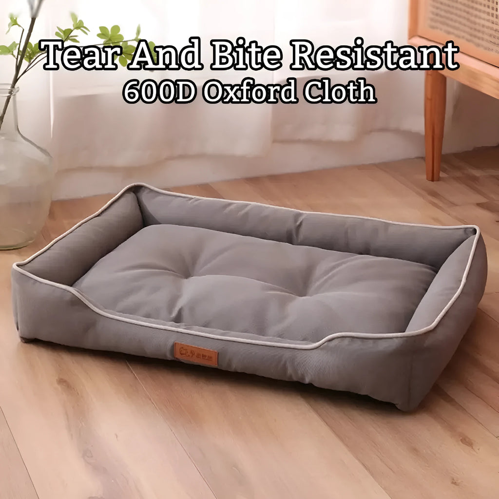 Grey waterproof dog sofa bed with raised edges on wooden floor