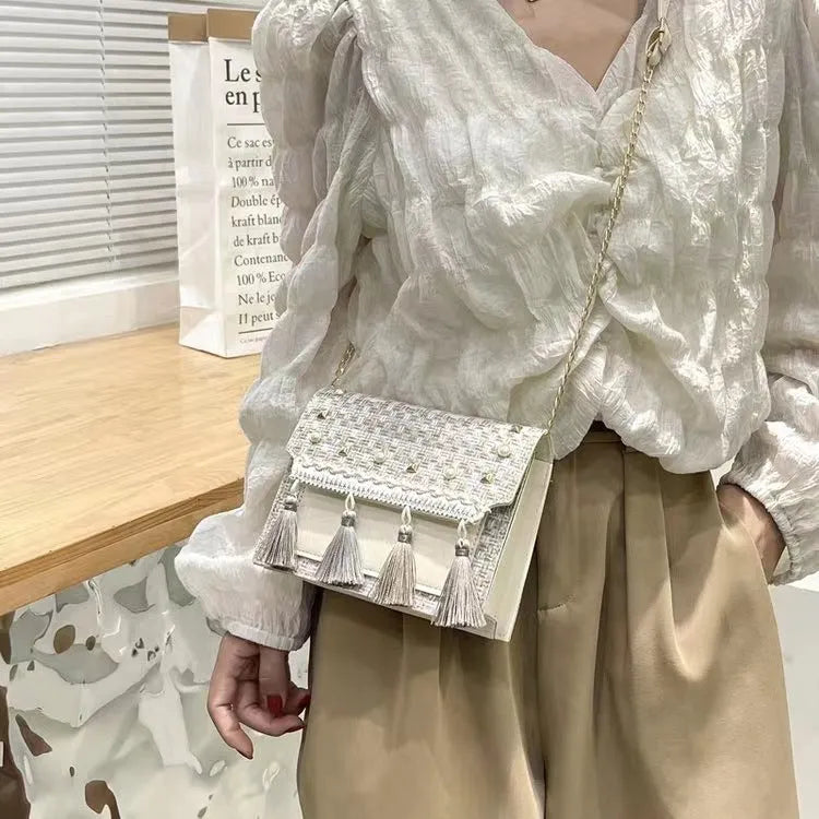 Ethnic-style horizontal square PU bag in beige with polyester lining, medium-hard structure, and flat lay on surface