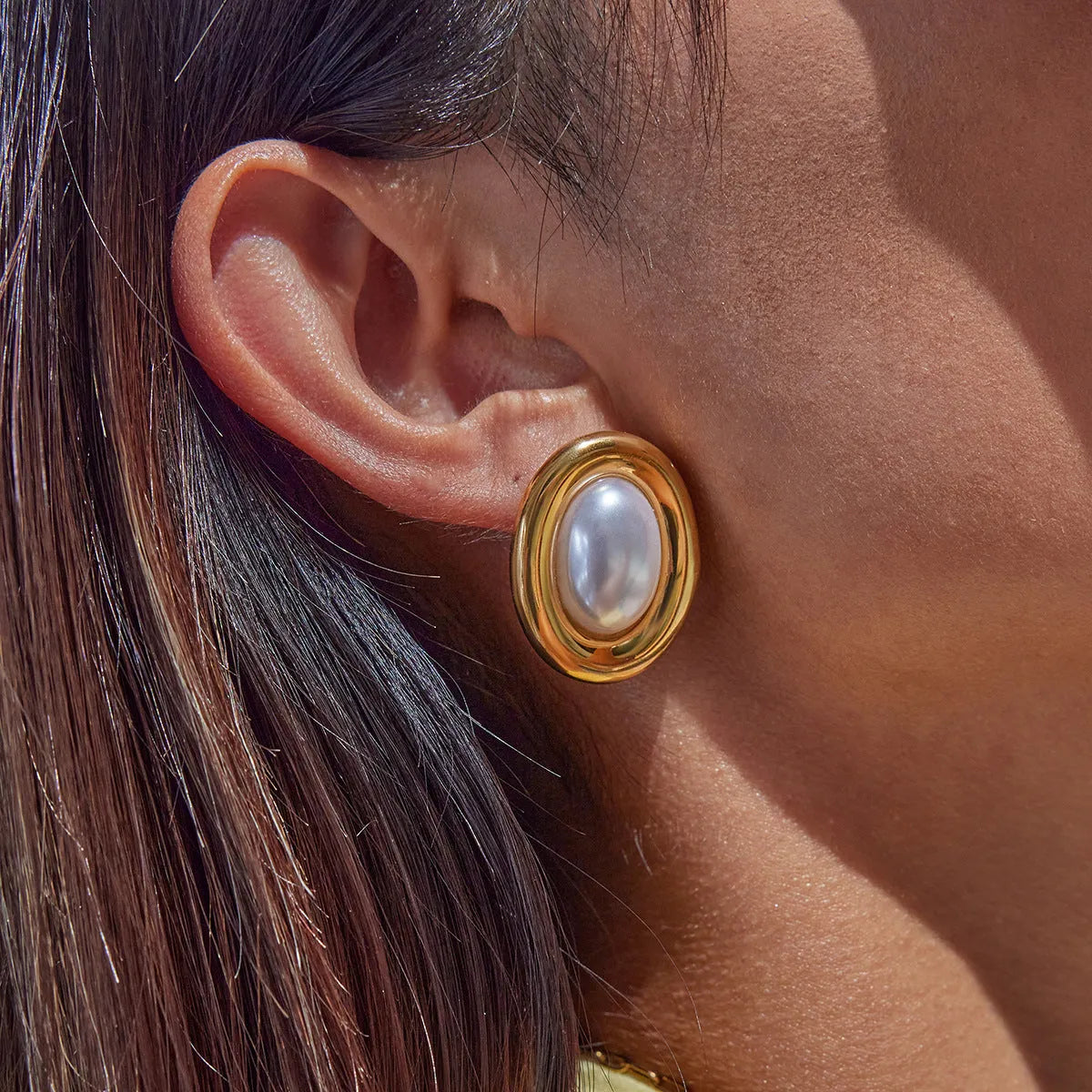 A pair of stainless steel vintage pearl stud earrings for women with a post-back closure.