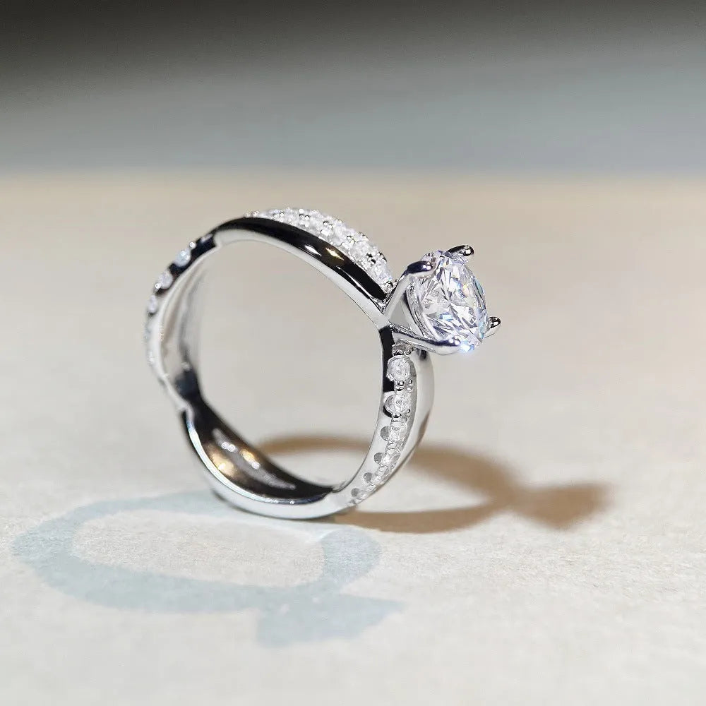 Geometric silver moissanite ring with a 1 karat stone and twisted band.