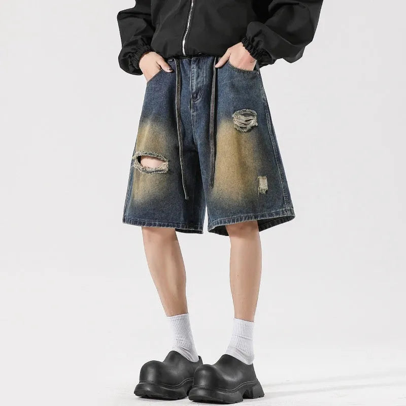 A pair of retro blue loose fit men's jeans with ripped detailing on the legs.