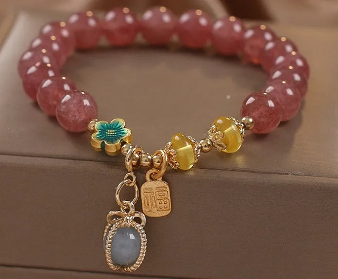 Red strawberry quartz beaded bracelet with metal alloy setting and sparkling rhinestone details.