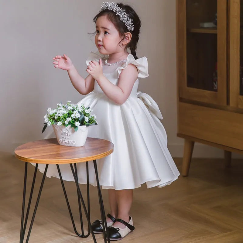 Girls' white satin princess dress with puff sleeves, full-length view, white fabric