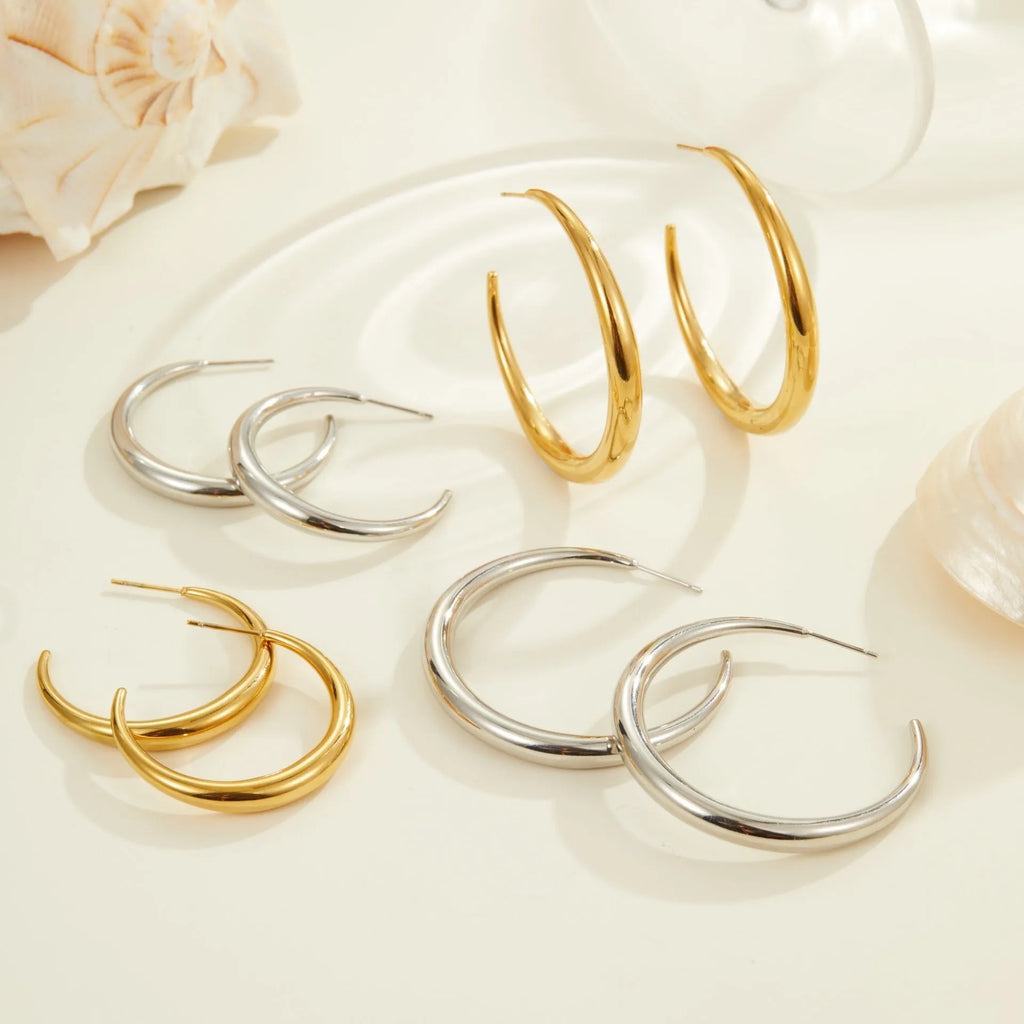Simple titanium steel hoop earrings in gold and steel finishes, available in large and small circular sizes
