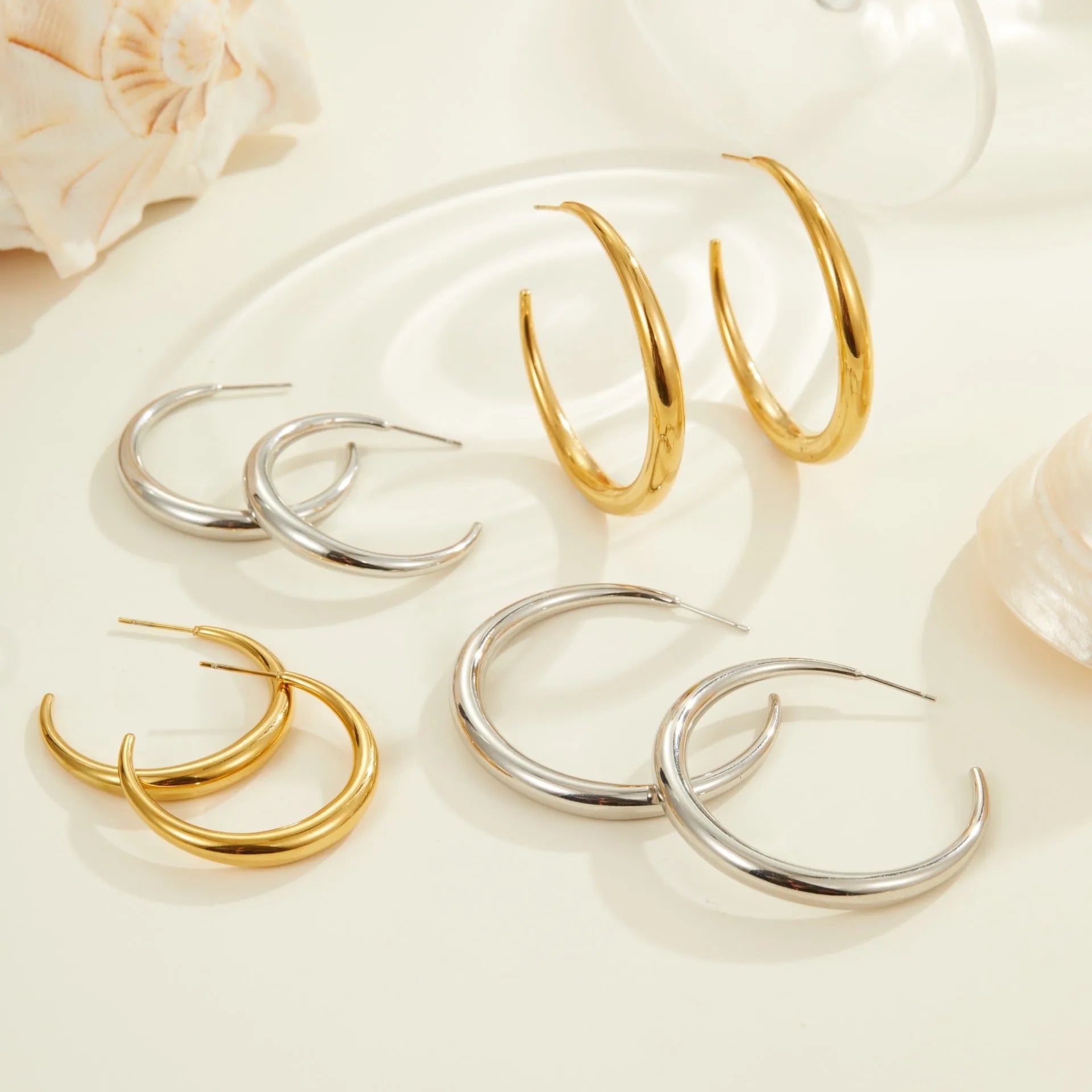 Simple titanium steel hoop earrings in gold and steel finishes, available in large and small circular sizes
