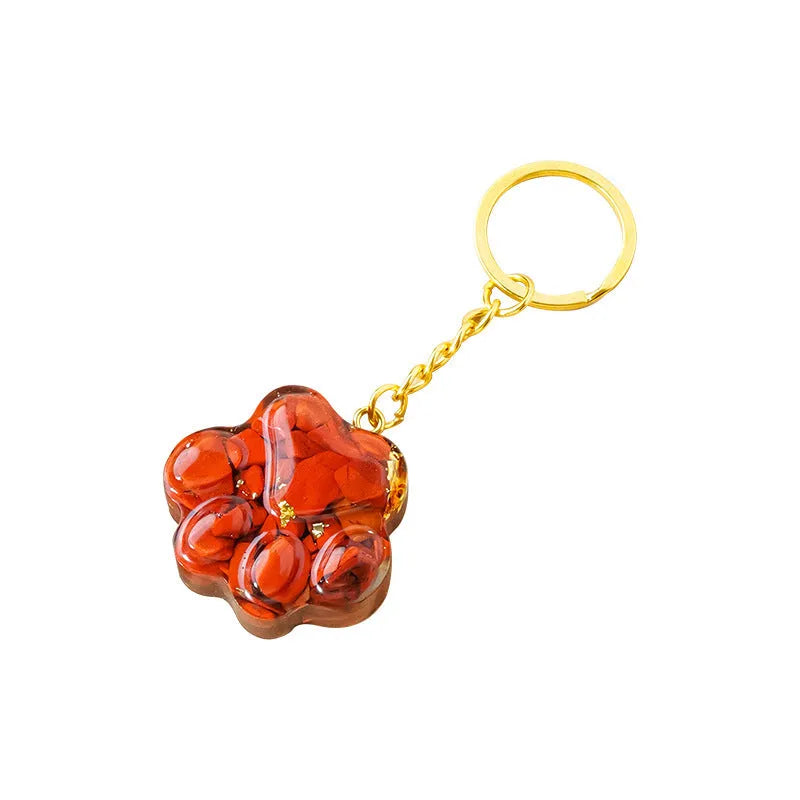 Hand-carved natural crystal cat's paw keychain pendant on a metal ring, showing unique gemstone colour.