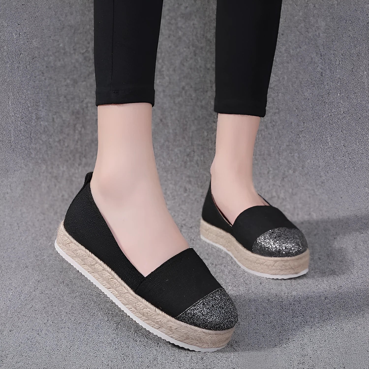 Beige and black women's canvas flat shoes with round toe and slip-on design.