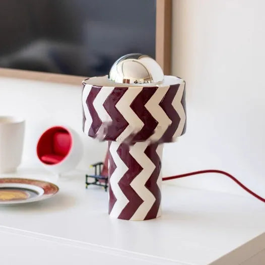 Striped table lamp with matte finish, pushbutton switch, and UK plug on a desk