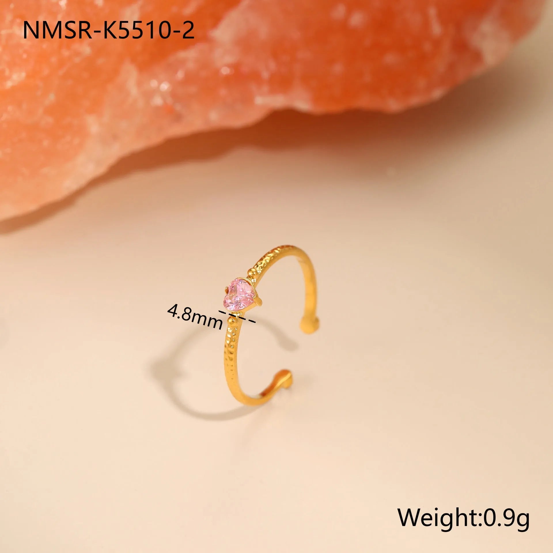 Open-ended geometric stainless steel ring with a green zircon heart inlay on a grey background.