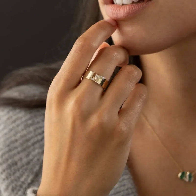 Gold-coloured women's ring with shining zircon stones on a copper band.