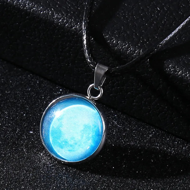 Luminous moon and star constellation pendant necklace with a silver-tone chain on a black background.