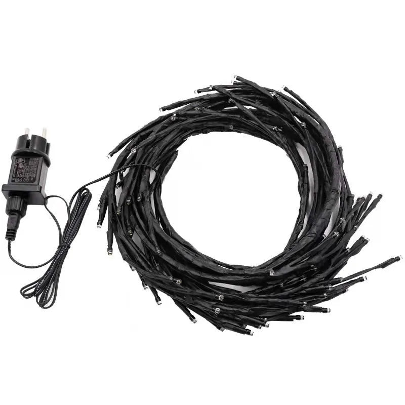 Flexible plastic willow vine LED garland light with warm white bulbs and birch bark texture.