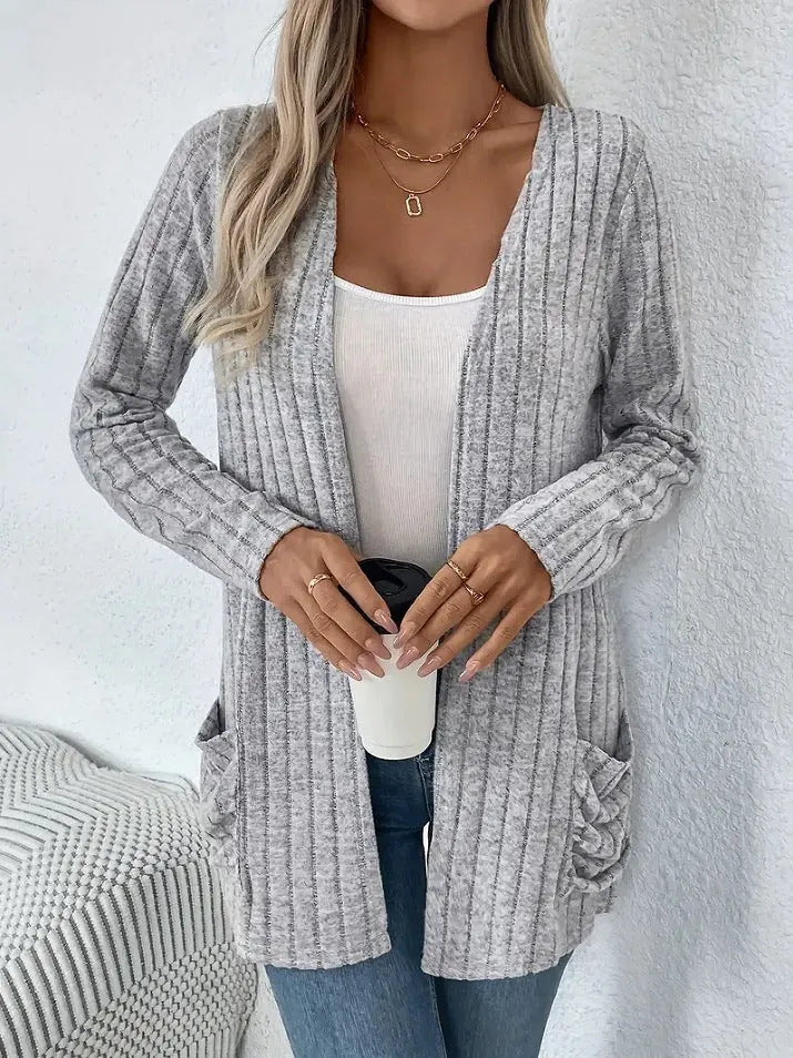 A person wearing a solid grey loose fit long sleeve cardigan with a chest pocket.