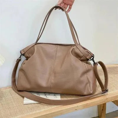 Large horizontal square soft-surface PU leather messenger bag with a long shoulder strap and zip opening.