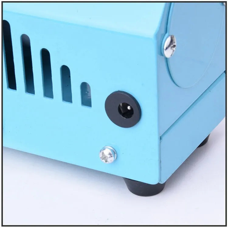Mini woodworking lathe in blue with steel chuck, drill bit, and protective cover on a desktop