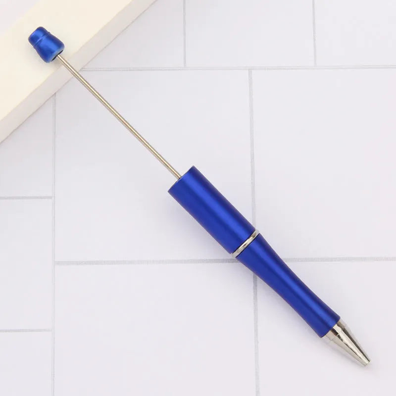 Colourful spinning ballpoint pen with plastic beads on a white background.