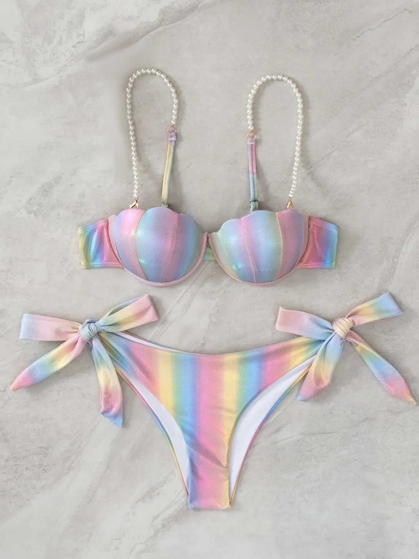 Women's rainbow colour adjustable tied bikini swimsuit on a hanger.