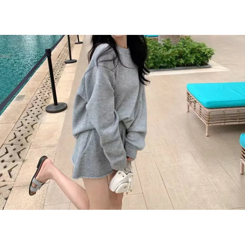 Women's loose grey acrylic knit sweater and wide-leg shorts set laid flat.