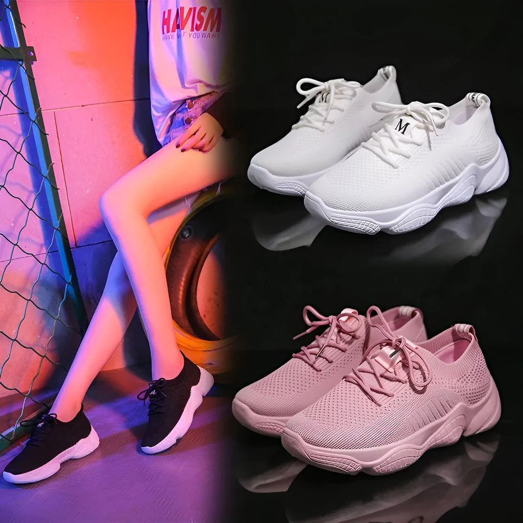 Women's low-top white sport shoes with thick rubber sole and woven upper, showing front strap closure.