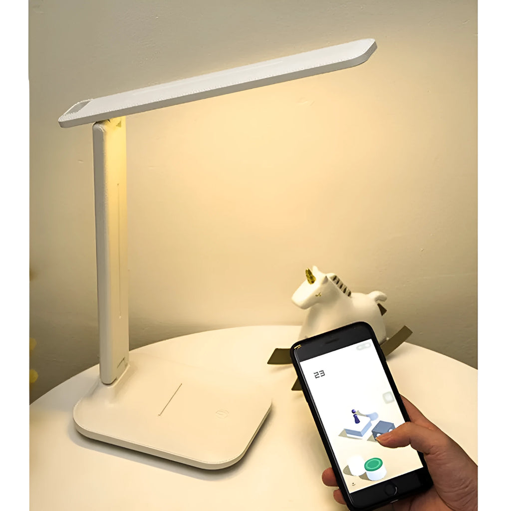 White plastic bedside lamp with touch dimming and colour-changing LED light on a table.