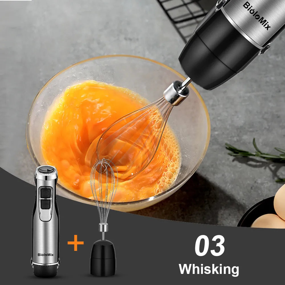 Silver Biolomix hand blender set with stainless steel attachments, chopper bowl, and blending beaker on a kitchen counter
