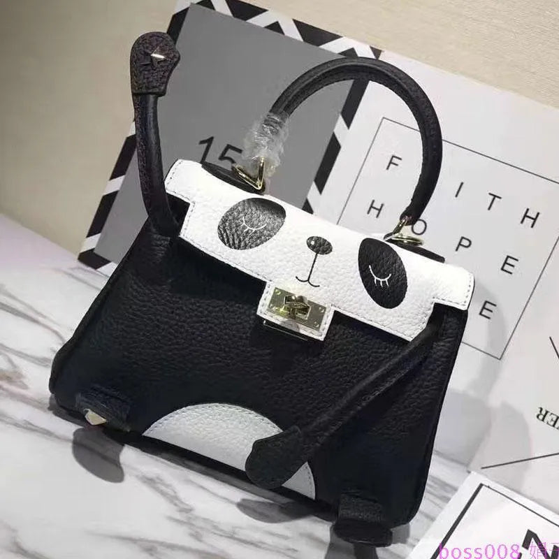 Black and white panda print on a structured horizontal square cowhide leather handbag with a trumpet detail.