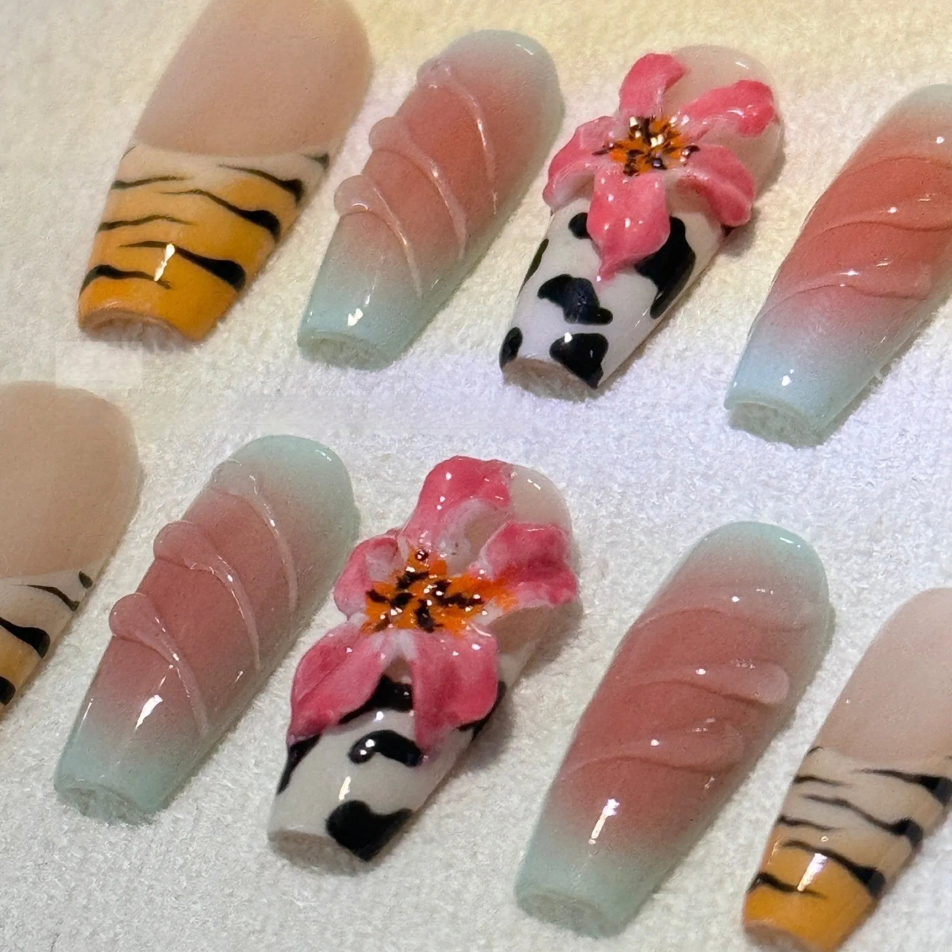 Hand-carved false nails with zebra pattern and lily designs in sizes XS through L
