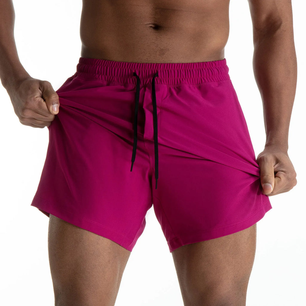 Men's black quick-drying sports shorts with mesh stitching detail on a grey background.