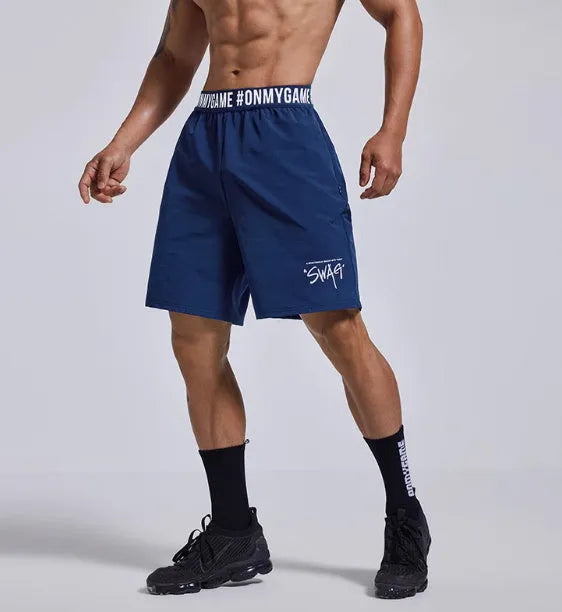 Men's loose black cropped sports shorts with an elastic waistband on a grey background