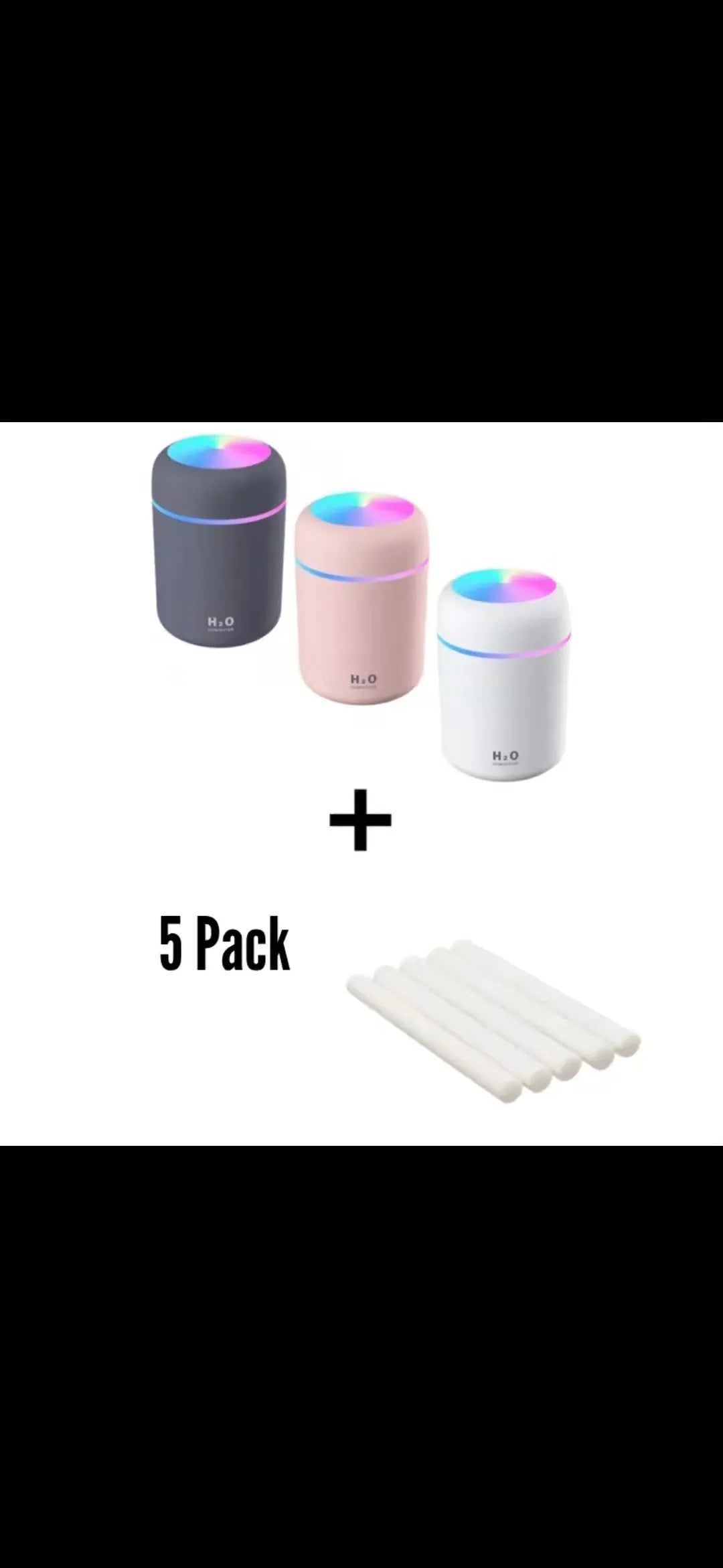 Pink USB mini humidifier with LED lights on wooden desk beside laptop
