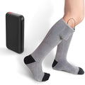 Electrically heated socks in black textile fabric with rechargeable ABS battery pack visible in pocket