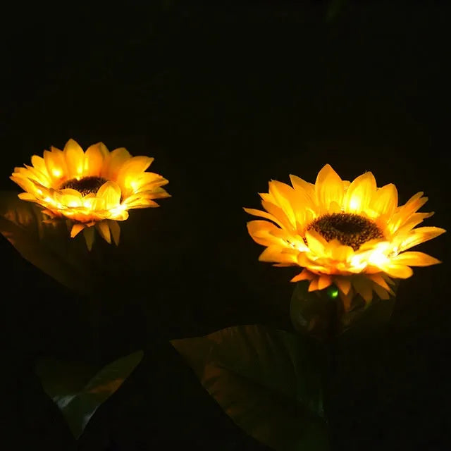 LED solar sunflower lamp with yellow fabric flower head, 66cm stainless steel stem, and ABS ground plug, placed on grass