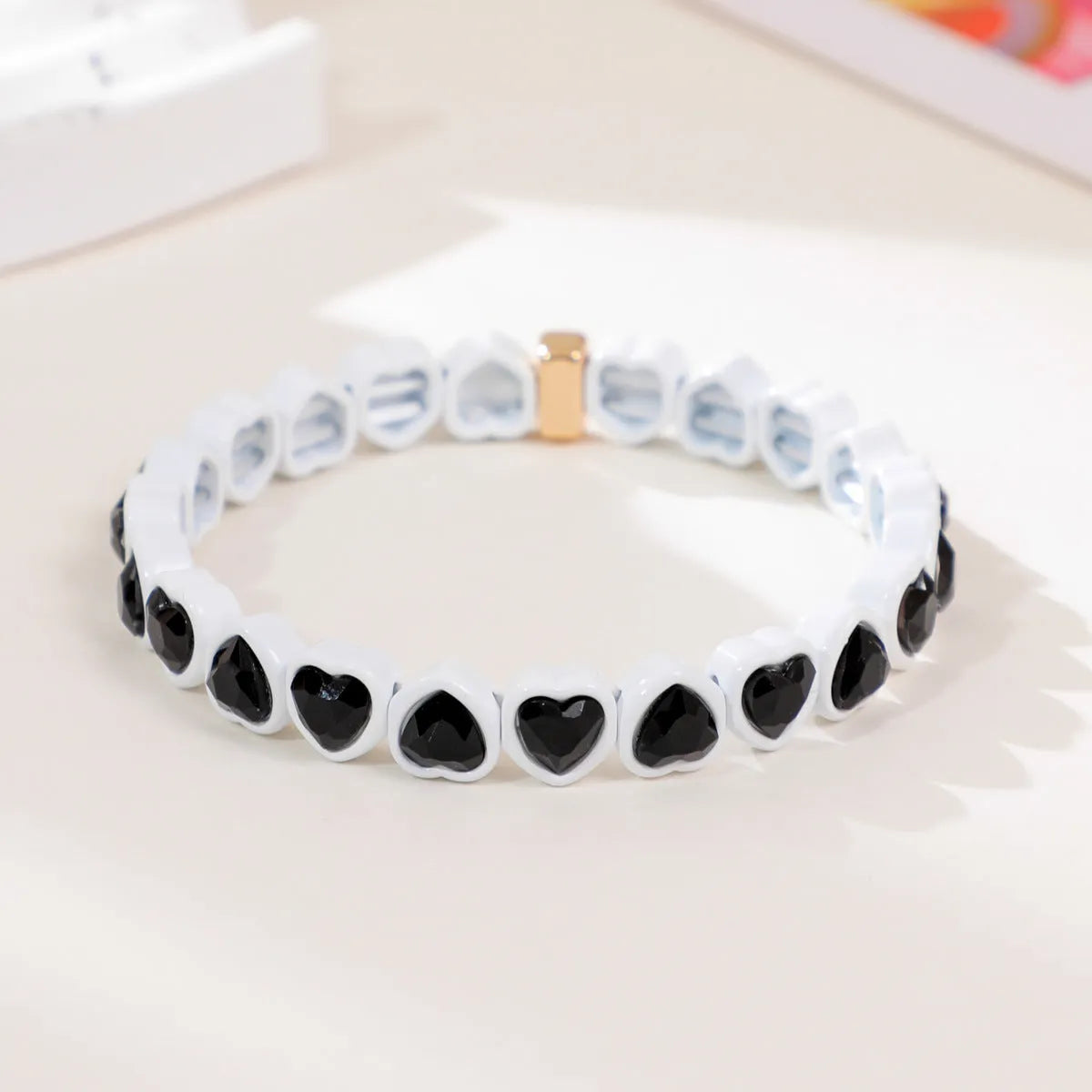Rainbow enamel heart charm bracelet on alloy base with diamond treatment, stretch band, multicolour design.