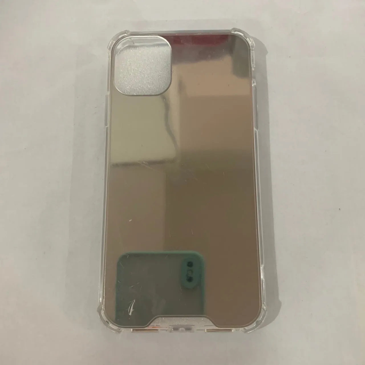 TPU mirror phone case for iPhone on a table, showing anti-fingerprint finish.