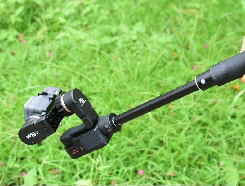 Black retractable aluminium selfie stick with Bluetooth remote, extended as a hand-held stabilizer.