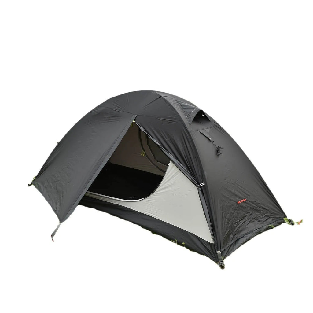 Red single person backpacking tent with aluminium poles pitched in a forest, showing double-layer design and vestibule.