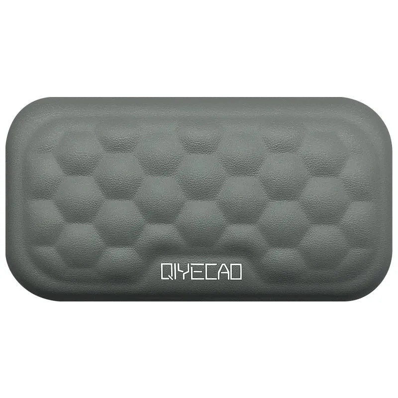 Grey and black memory foam mouse wrist rests with cloth or leather covers on a desk.
