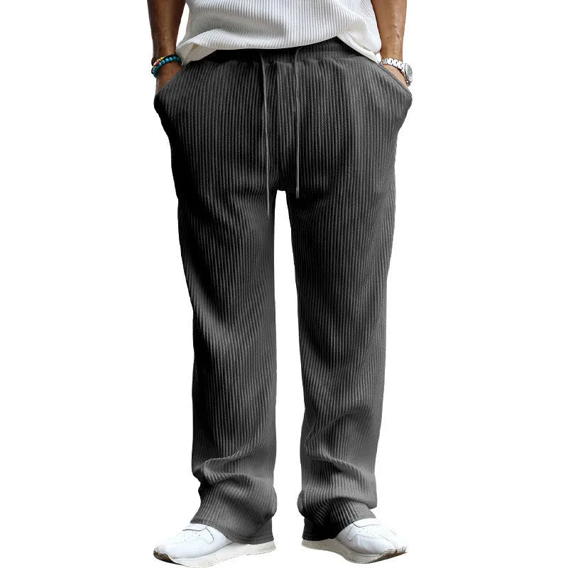 Man wearing loose high-waisted straight-leg casual trousers in army green.